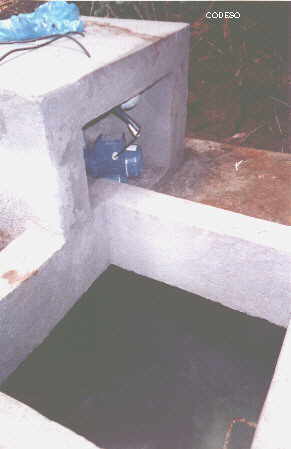 El tanque de acumulación de agua con la bomba - foto